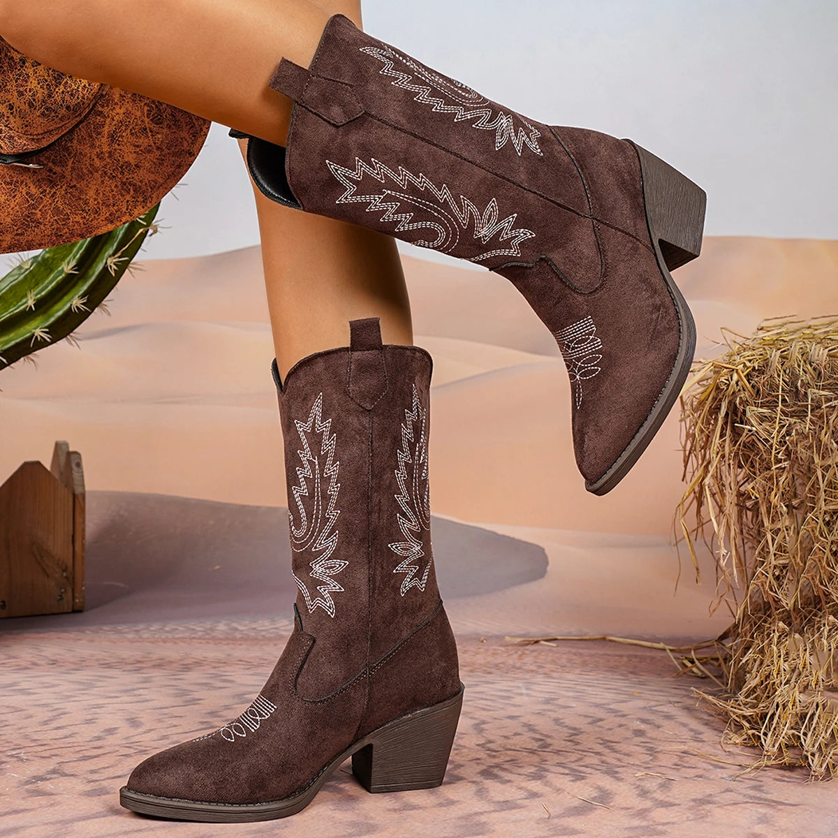 Embroidered western cowboy boots in mid-calf height with intricate stitching detail and square heel