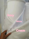 Close-up of luxurious satin texture and intricate pearl details on the custom-fit wedding dress.
