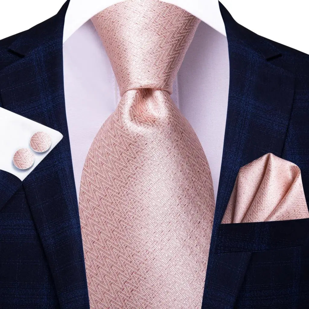 Coordinated formal wear set featuring lustrous paisley tie, handkerchief, and polished cufflinks