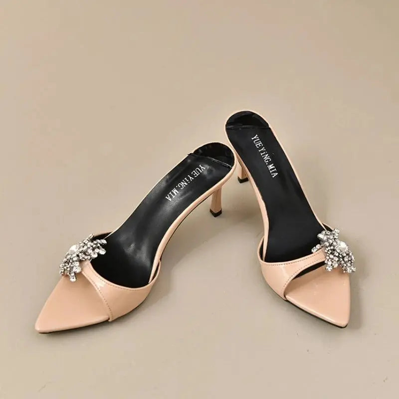 Elegant high-heeled mules with shimmering rhinestones and flower embellishments.