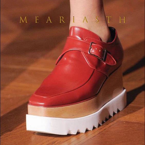Black leather platform wedge sneakers with slip-on design on white background