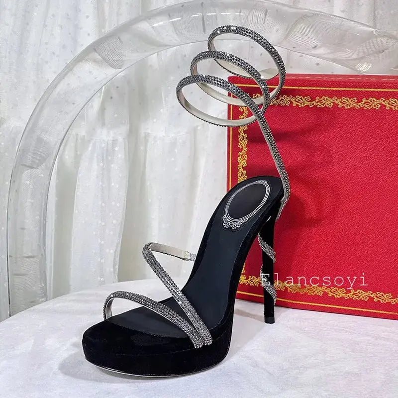 Side view of black stiletto heels showcasing the secure ankle strap.