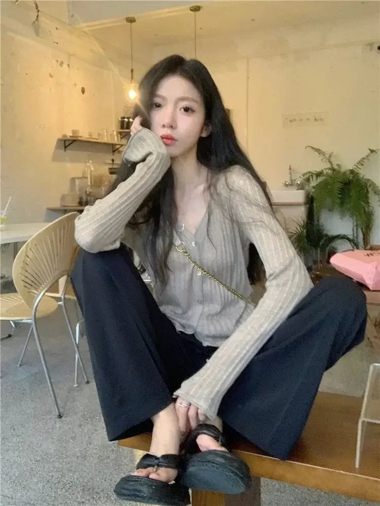 Autumn Whisper Cardigan draped over a chair, emphasizing its cozy texture and warmth.