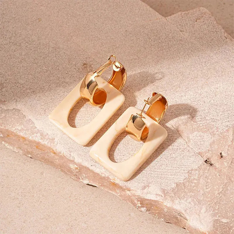 Trendy women's statement earrings featuring a striking geometric shape and glossy appeal.