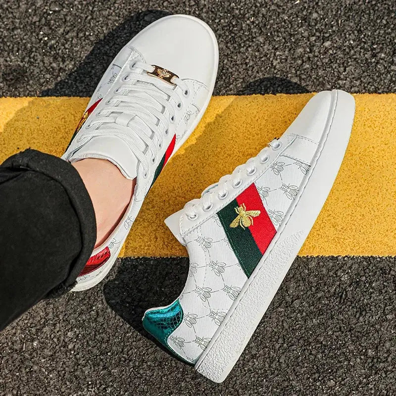 Close-up of artisan bee embroidery on premium white leather sneaker with breathable perforated details