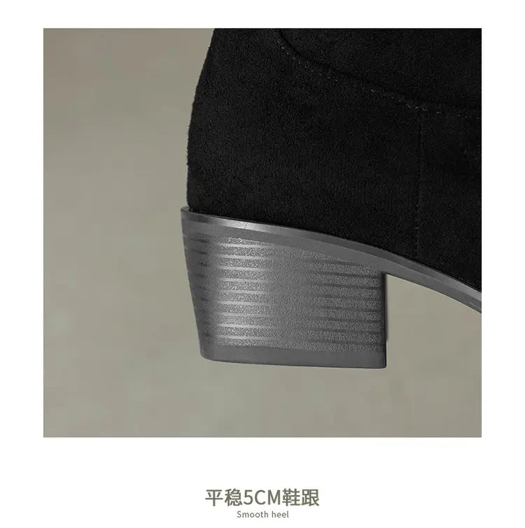 Close-up of leather texture and embroidered detail on boot calf