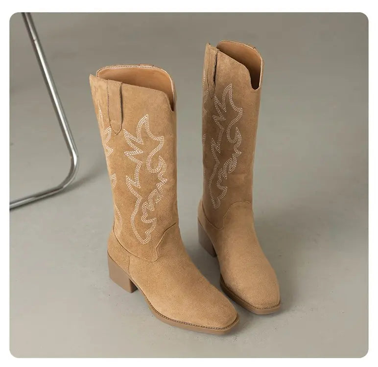 Tan leather Western boots with traditional embroidered storytelling designs