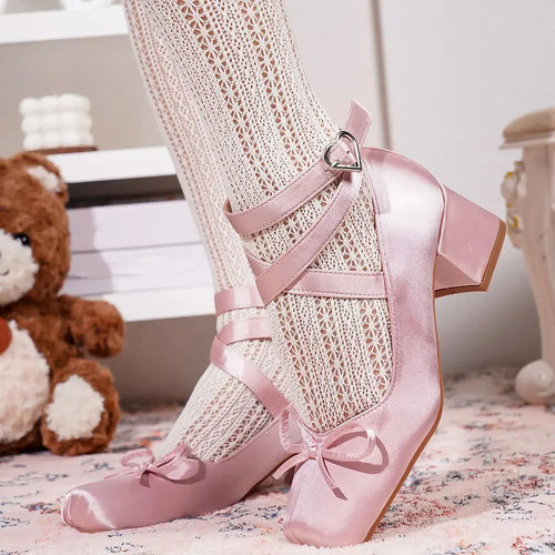 Blush satin heels with elegant cross straps and square toe design.