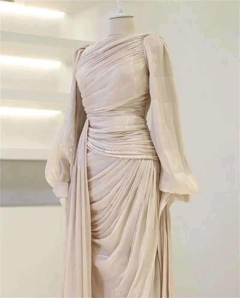 Ethereal silk kaftan in soft ivory with flowing long sleeves and elegant pleating.