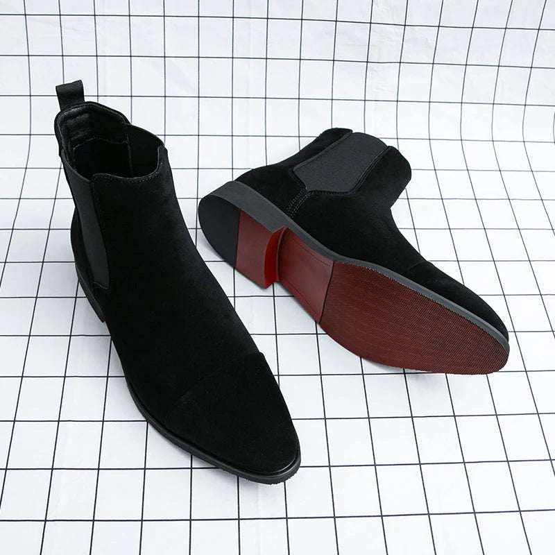 Side view of slip-on Chelsea boots showing streamlined profile and contrasting red rubber outsole