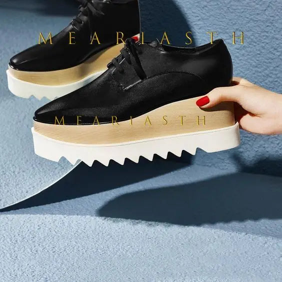 Black leather wedge sneakers featuring slip-on style and elevated platform sole