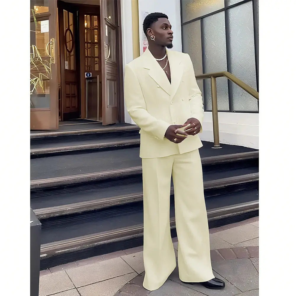 Front view of a model in a black double-breasted suit at a wedding.