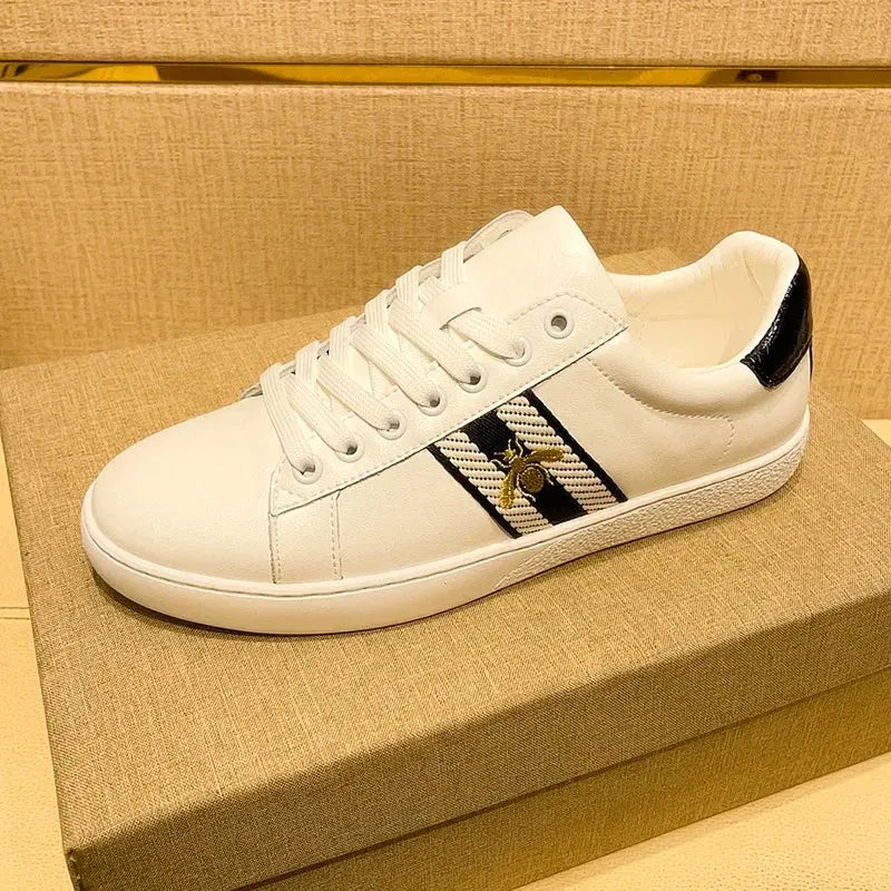 White leather skate sneakers with gold embroidered bee detail and breathable microfiber accents on clean background