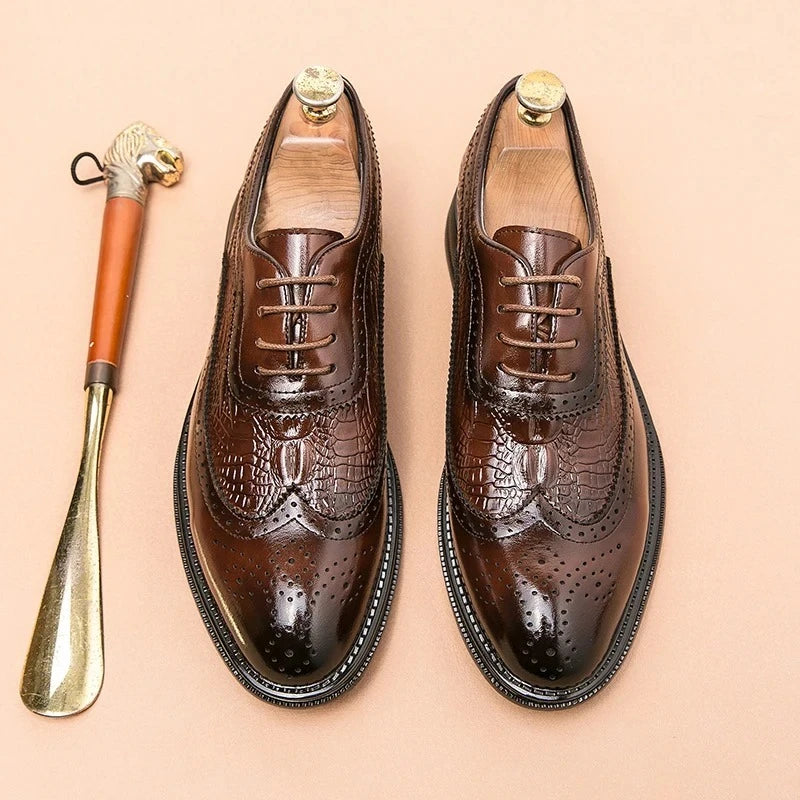 Black leather brogue dress shoes with wingtip detailing and pointed toe on white background