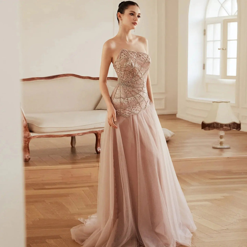 Enchanting blush gown in soft tulle with intricate beadwork and sequins.