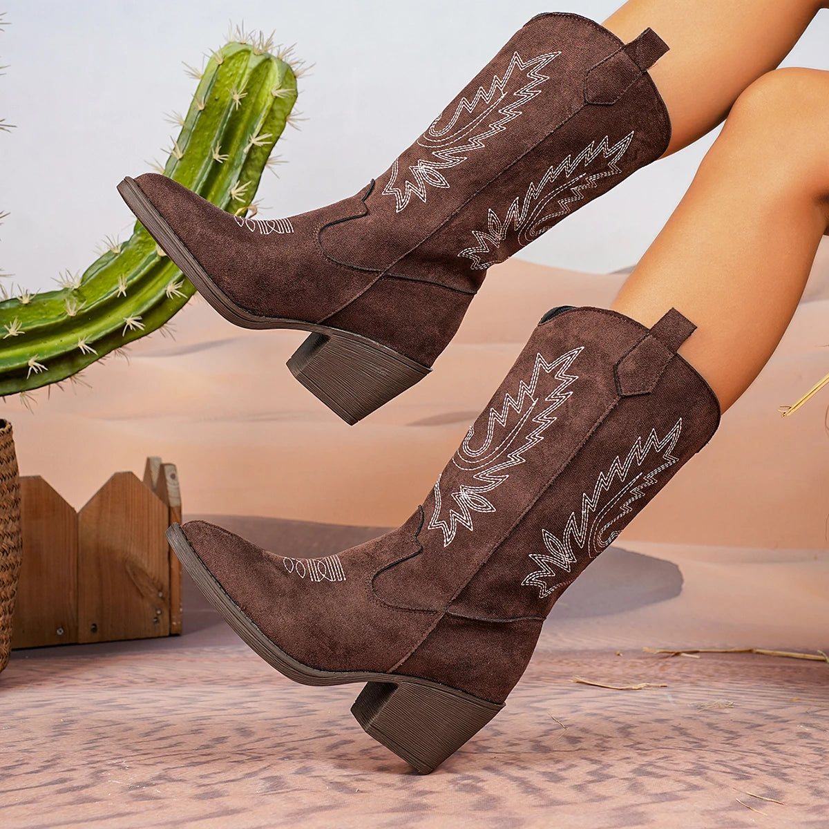 Mid-calf height cowboy boots with ornate embroidery detailing and easy slip-on construction