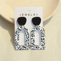 Whispering Leaves Drop Earrings in light acrylic, showcasing a geometric design and subtle elegance.