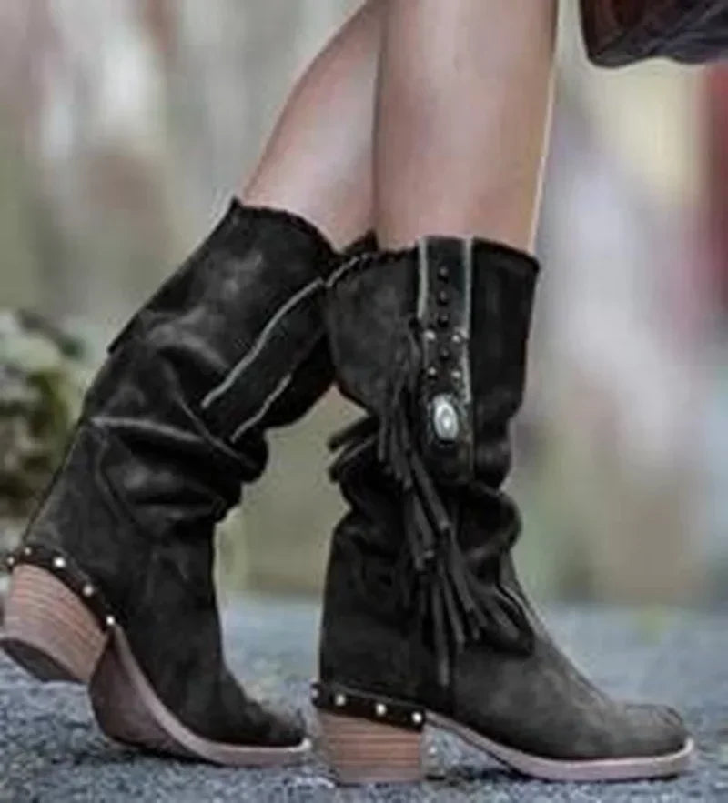 Detail shot of metal embellishments and fringe tassels on faux suede boot