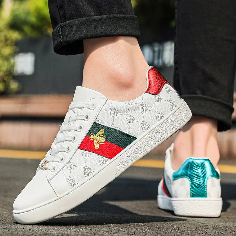 Top angle view of breathable leather sneakers showcasing embroidered bee detail and precision fit construction