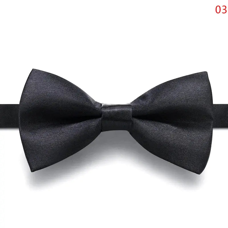 Matte finish black bow tie paired with a tuxedo, showcasing formal elegance.