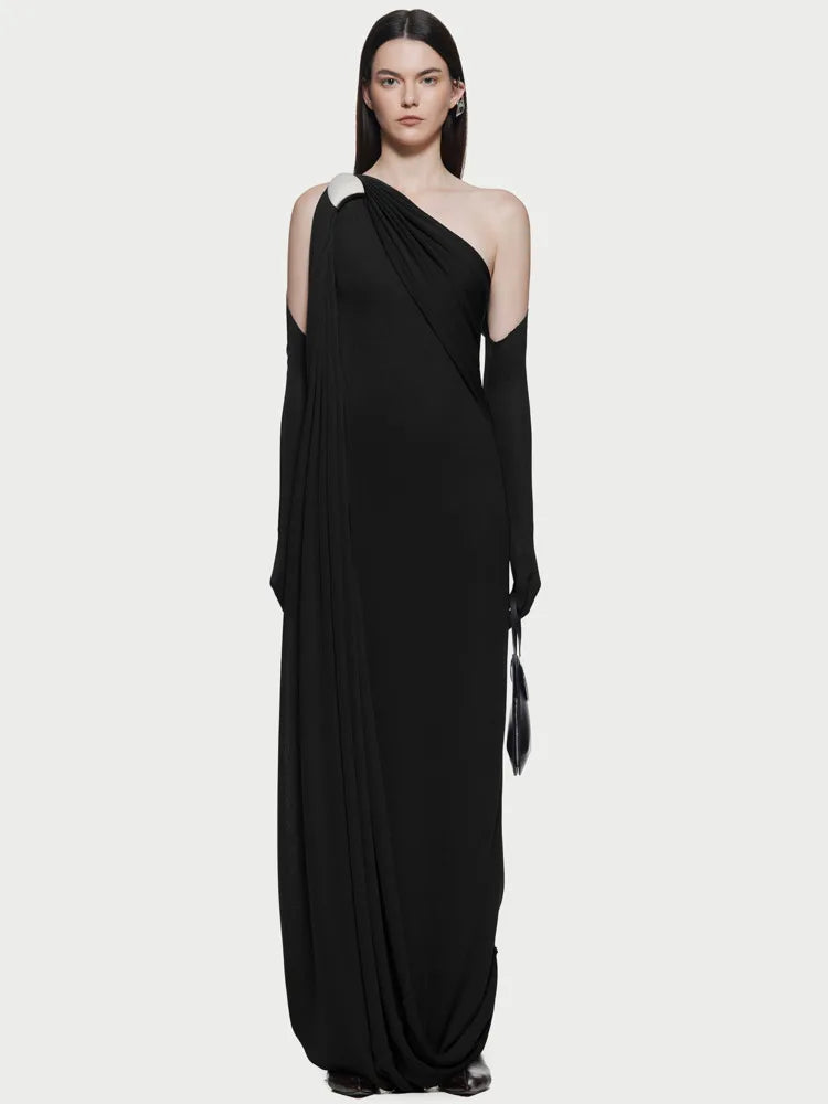 Close-up of pleated detail on the asymmetrical hem of the evening dress.