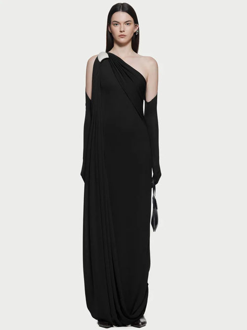 Close-up of pleated detail on the asymmetrical hem of the evening dress.