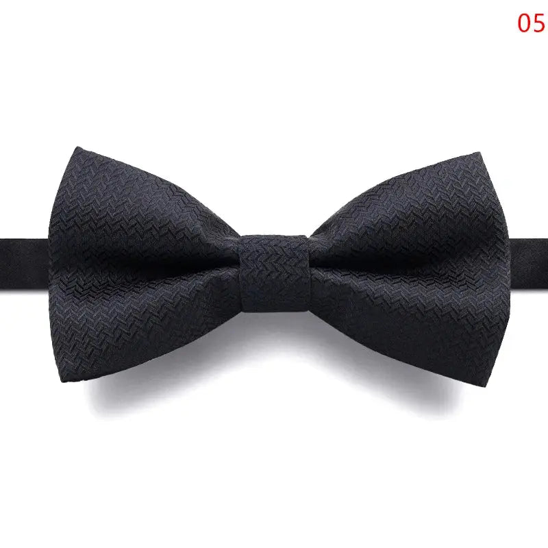 Black bow tie being adjusted, symbolizing confidence and sophistication.