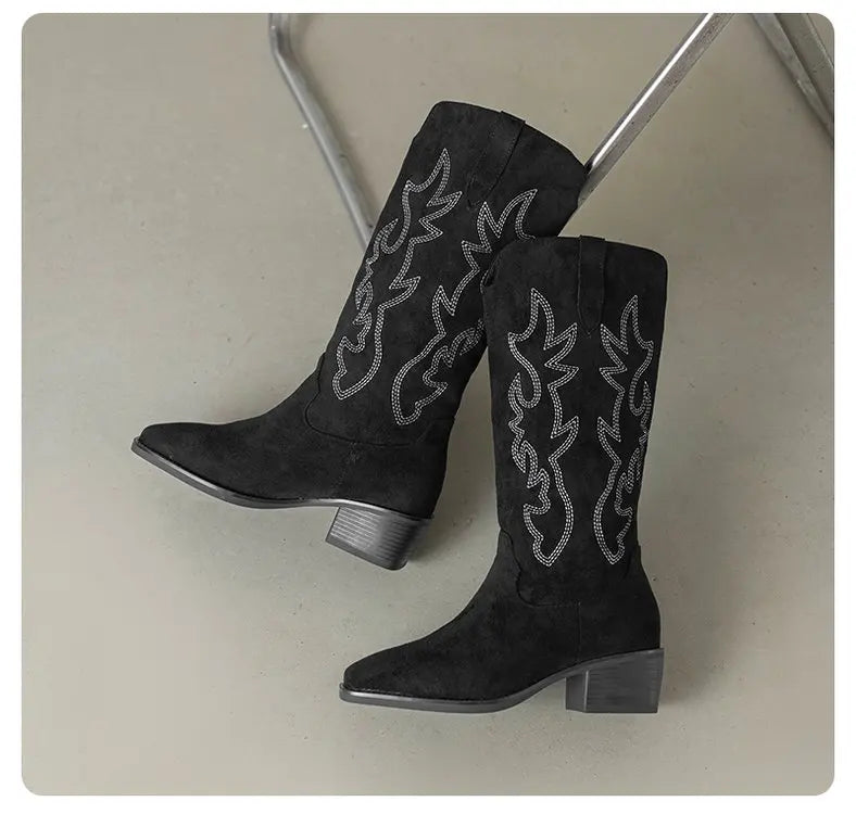 Woman in embroidered knee-high boots at morning coffee shop