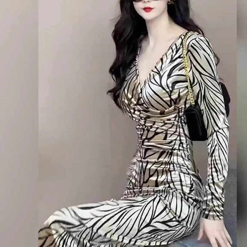 Mid-calf length champagne leopard dress with stretchy fabric and feminine V-neck design