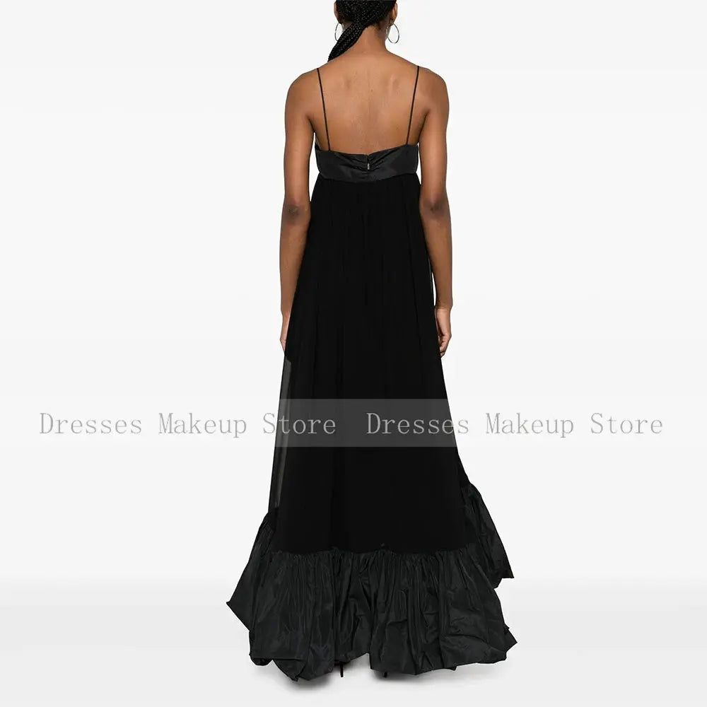 Close-up of ruched detailing and delicate ruffles on the black satin gown.