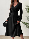 Midnight Allure dress in black with twisted knot detail at the waist and lantern sleeves.