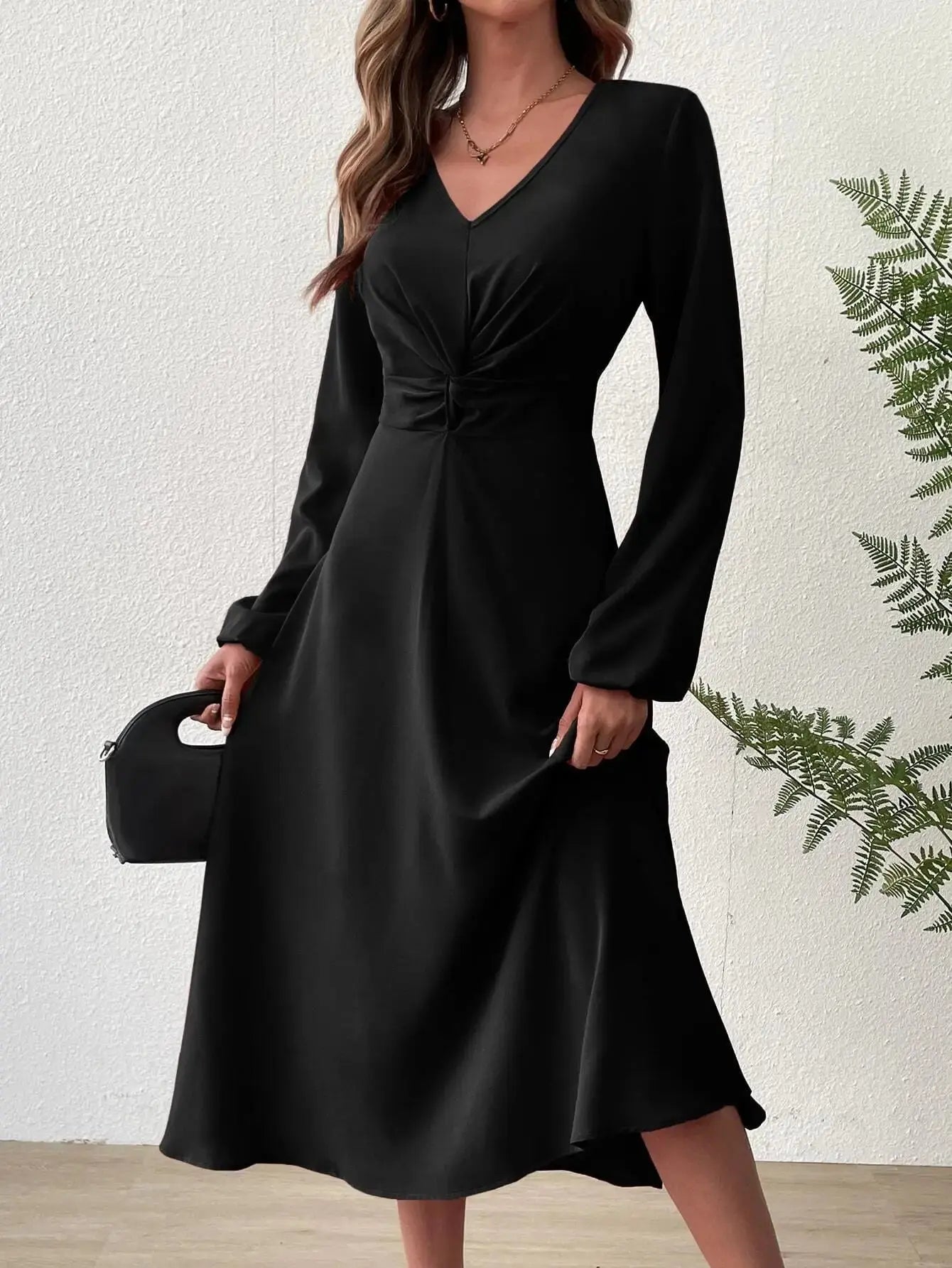 Midnight Allure dress in black with twisted knot detail at the waist and lantern sleeves.