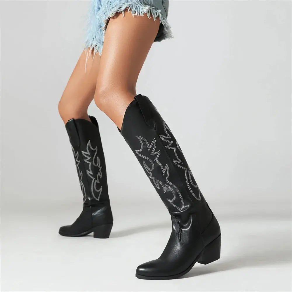 Embroidered vegan leather knee-high cowboy boots with intricate stitching and mid-block heel on white background