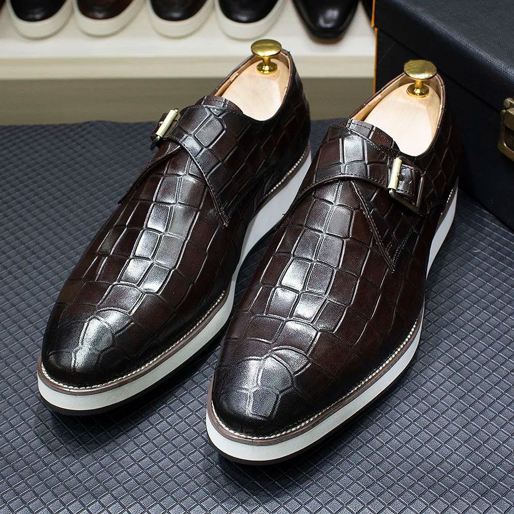 Detail of monk strap buckle closure on crocodile embossed leather dress shoes in classic black finish