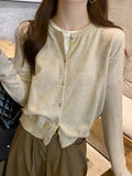 Whisper-Soft Cardigan draped over a chair, showcasing its durable fabric and elegant silhouette.