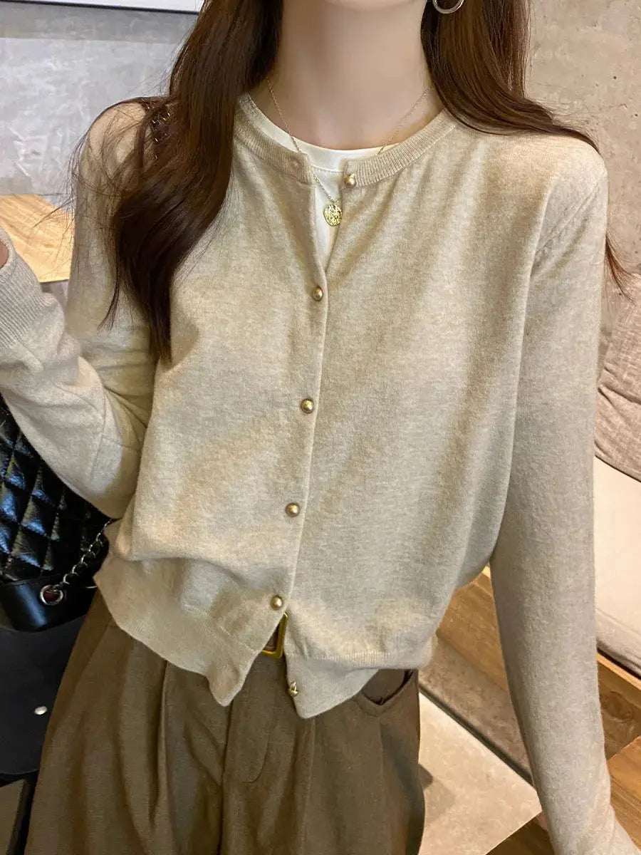 Whisper-Soft Cardigan draped over a chair, showcasing its durable fabric and elegant silhouette.