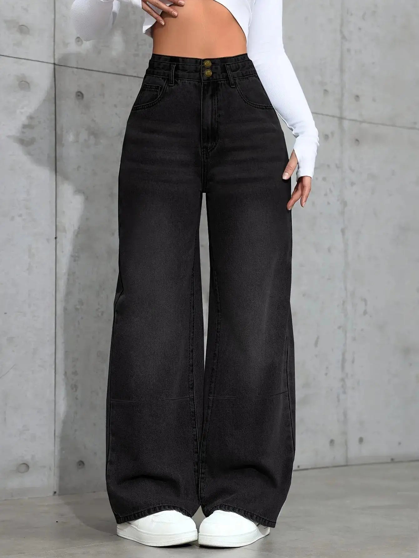 Model wearing high-waist jeans, exuding confidence and style in a casual coffee shop setting.