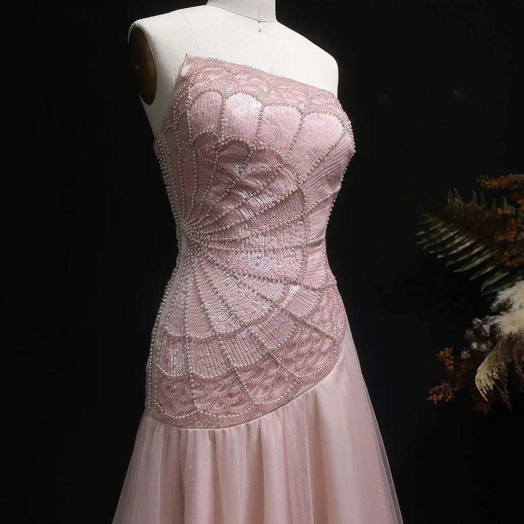 Close-up of beadwork and sequins on the enchanting blush gown catching light.