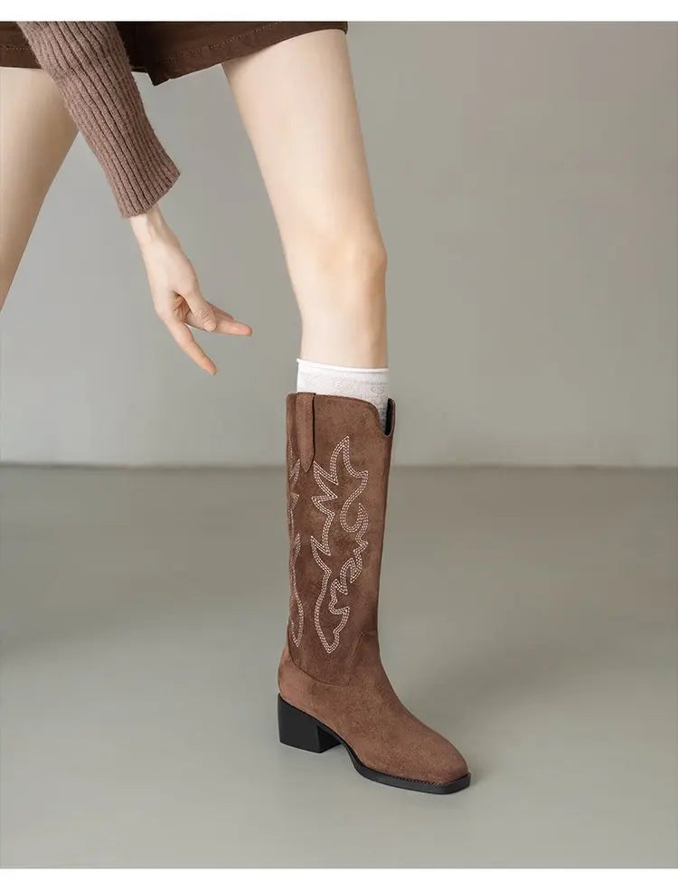 Slip-on cowboy boots with artisan totem embroidery and leather construction