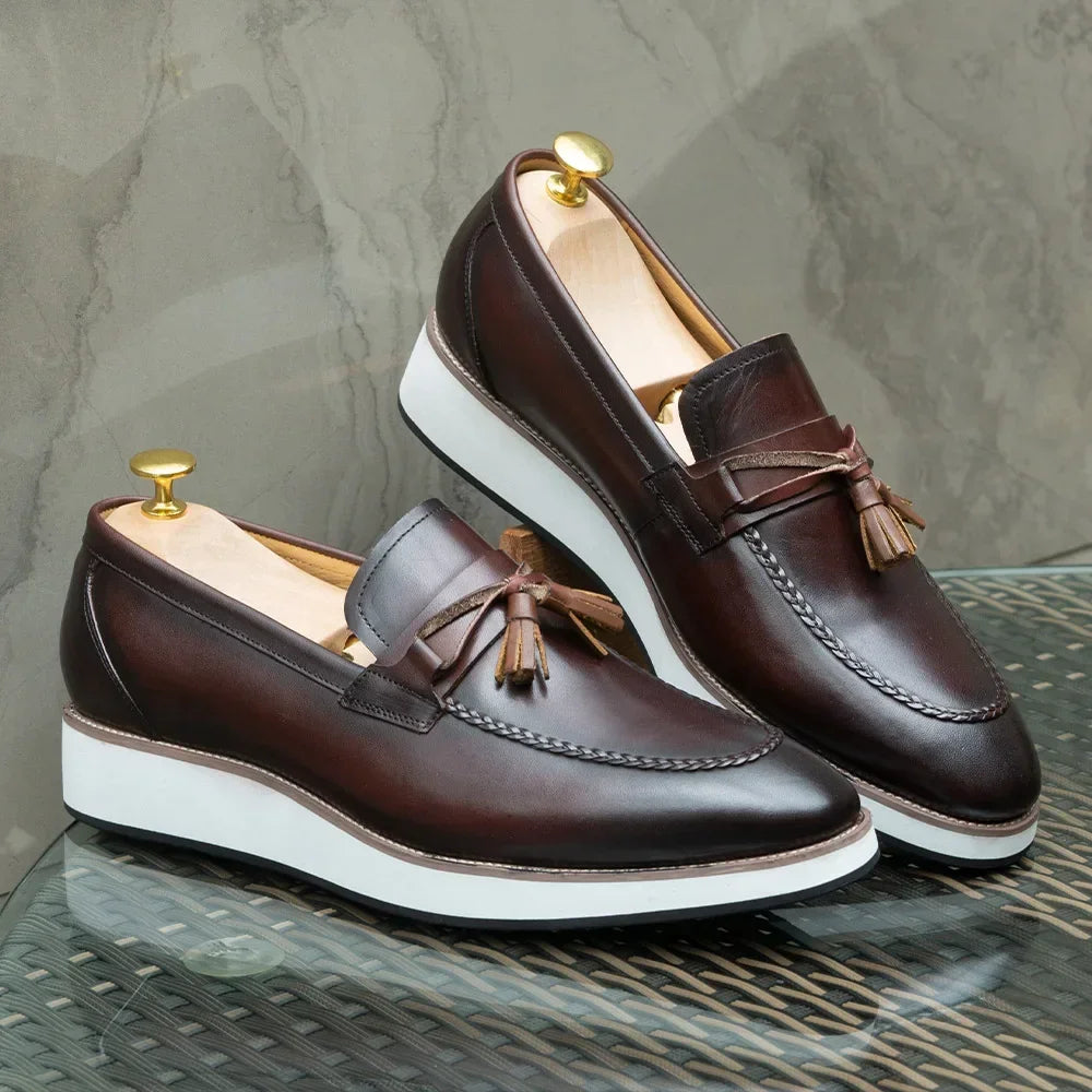 Detail shot of tassel loafer fringe and premium calfskin leather texture with natural patina