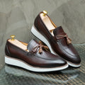 Detail shot of tassel loafer fringe and premium calfskin leather texture with natural patina