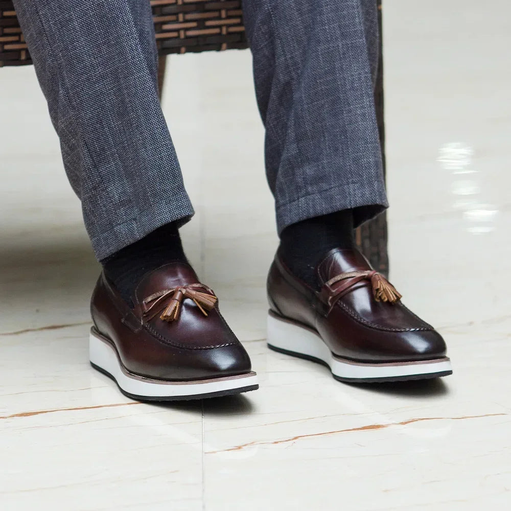 Side view of handcrafted tassel loafers showing supple calfskin leather and elegant silhouette