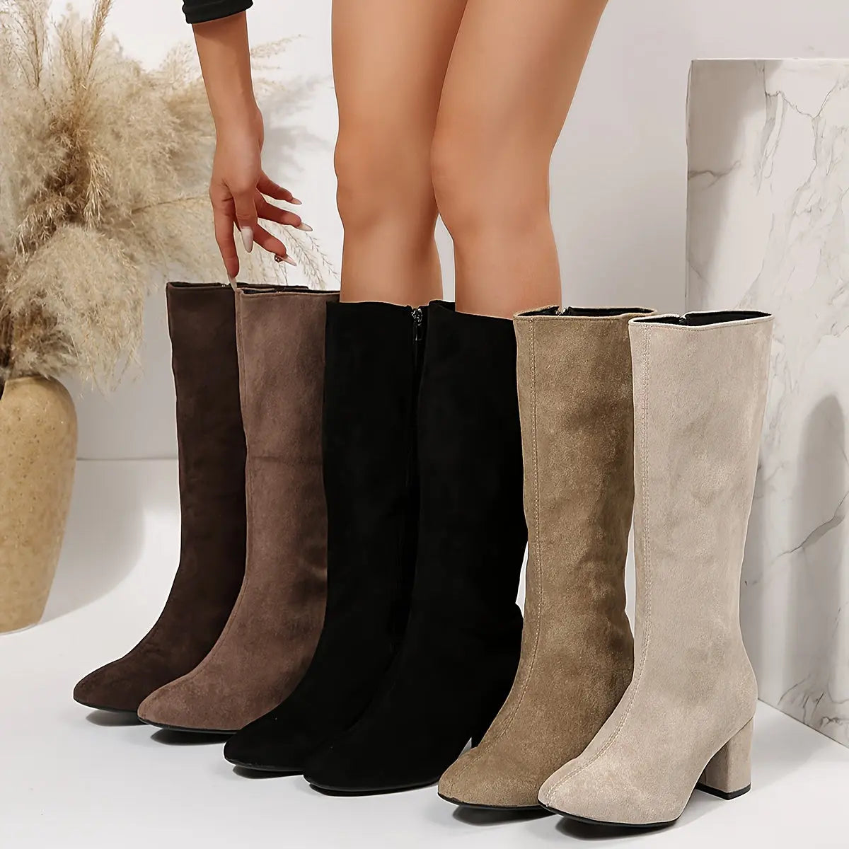 Black over-the-knee boots with a bold twist and block heel design.